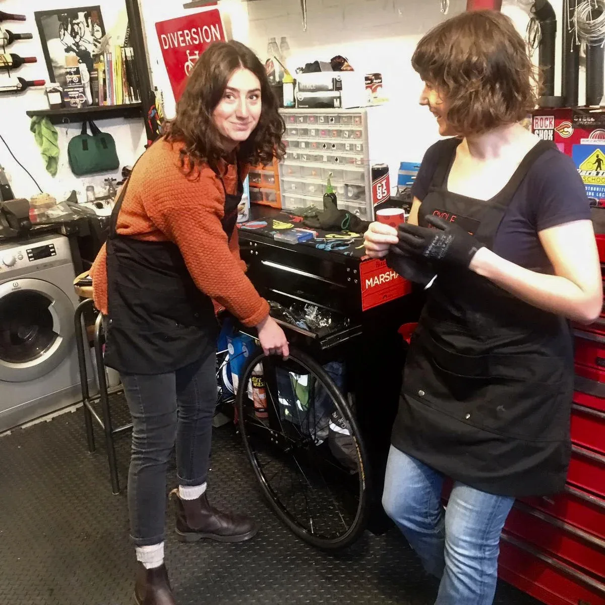 Two people learning bike maintenance in the studio